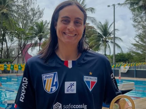 Germana Asfor com o troféu, à beira da piscina, com o uniforme do Fortaleza Raia 4