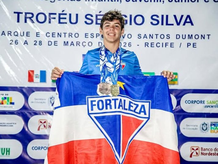 Vinícius Diógenes no pódio do Troféu Sérgio Silva, em Recife, com a bandeira do Fortaleza e duas medalhas