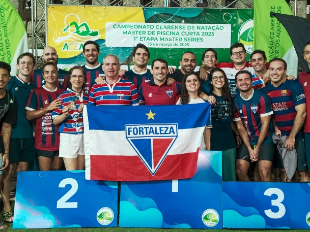 Atletas da equipe master da Raia 4 reunidos no pódio com a bandeira do Fortaleza
